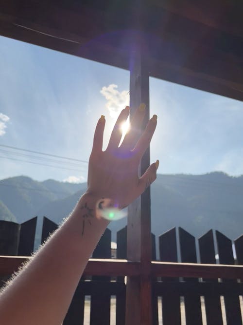 Hand Covering Sun in Sky