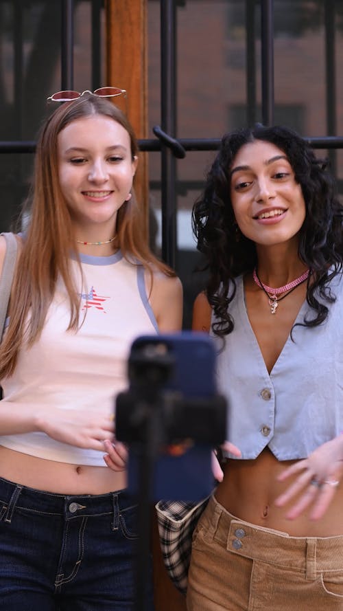 Two Young Women Talking while Recording a Video with a Smartphone