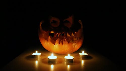 Burning Candles and a Spooky Carved Pumpkin 