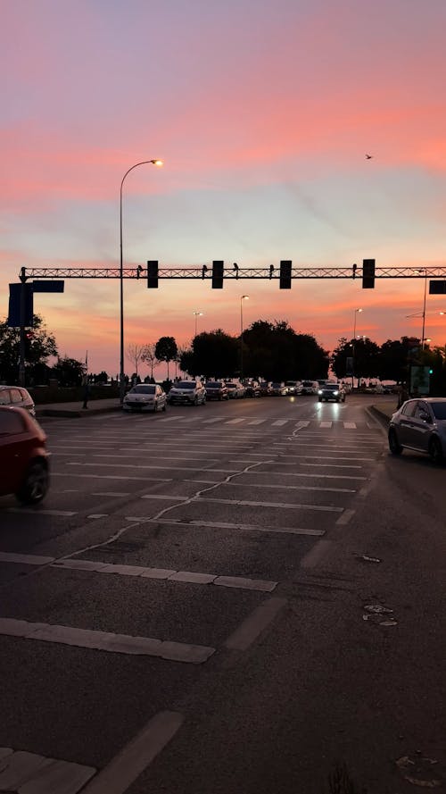 Traffic and Pedestrians on a City Street at Sunset 