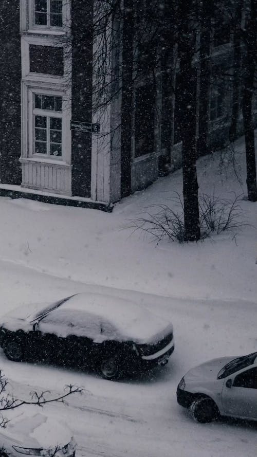 A Minivan Driving on Snow Covered City Street 