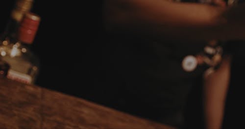 Close up of a Bartender Holding a Bottle of Whiskey 