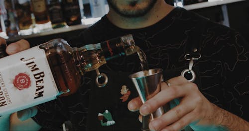 Close up of a Barman Pouring Bourbon into a Jigger 