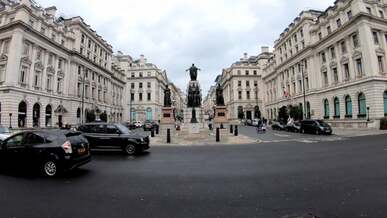 vehicles and pedestrians passing by the guards crimean war memorial in london