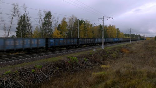 Drone Video of a Cargo Train Passing by a Rural Area