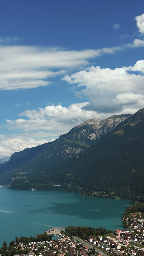 Body of Water Near Houses and Mountains 