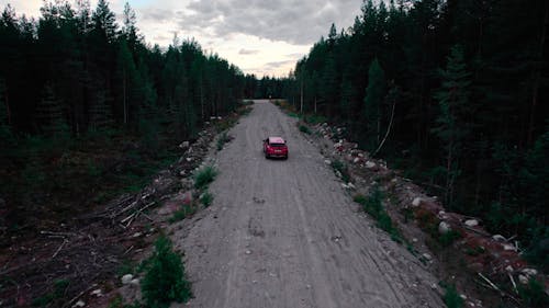 Drone Shot of Red Car Moving Fast on Dirt Road 