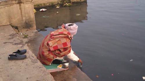 A Man Praying at Yamuna River Ghat in New Delhi, India