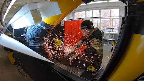 A Factory Worker Using an Angle Grinder on a Metal Piece