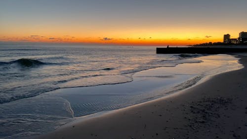 Sea Waves on a Sandy Beach at Sunset 