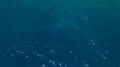 drone footage of the blue sea and a rocky coast