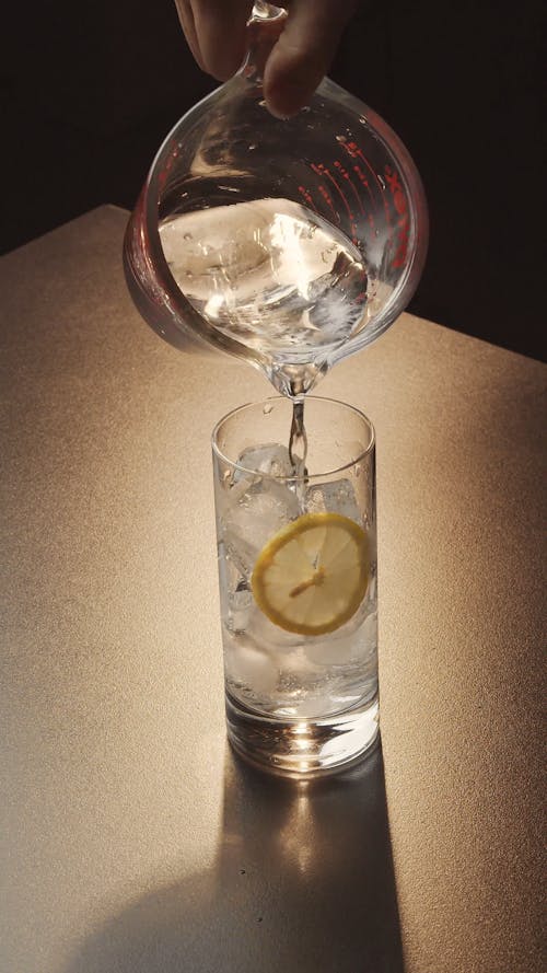 Pouring Water into Glass with Ice Cubes