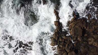 top view of breaking waves on a rocky shore