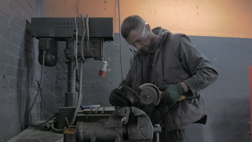 A Man Cutting Metal with an Angle Grinder 
