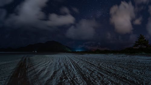 Time Lapse of a Night Sky with Passing Clouds over the Beach 