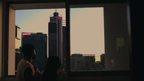 Couple Looking at Skyscraper Through Window