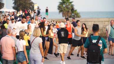 a group of dancers and musicians performing on a crowded promenade