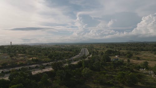 Drone Footage of a Country Road under a Cloudy Sky 