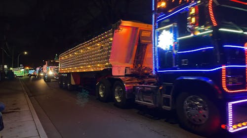 A Parade of Trucks Decorated with Christmas Lights