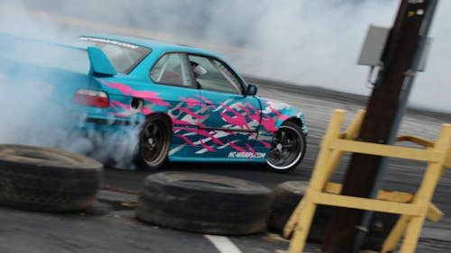 A Blue Car Drifting on the Road