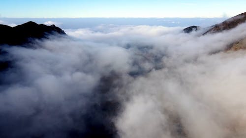 Drone View over a Cloudy Mountain Valley 