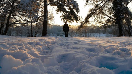 A Person Walking on a Snow Covered Ground