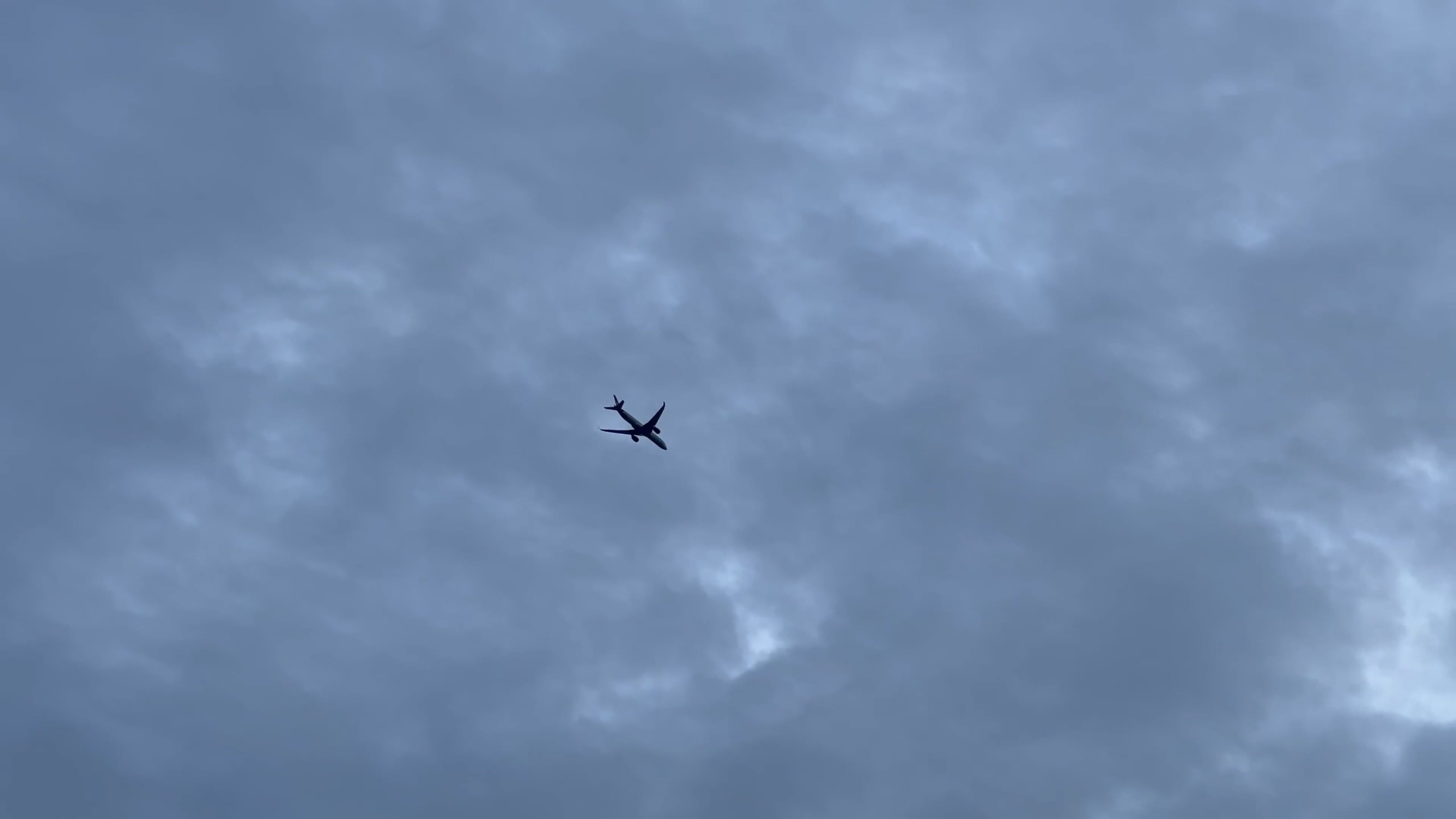 A plane flying through the cloudy sky with a blue sky Free Stock Video ...