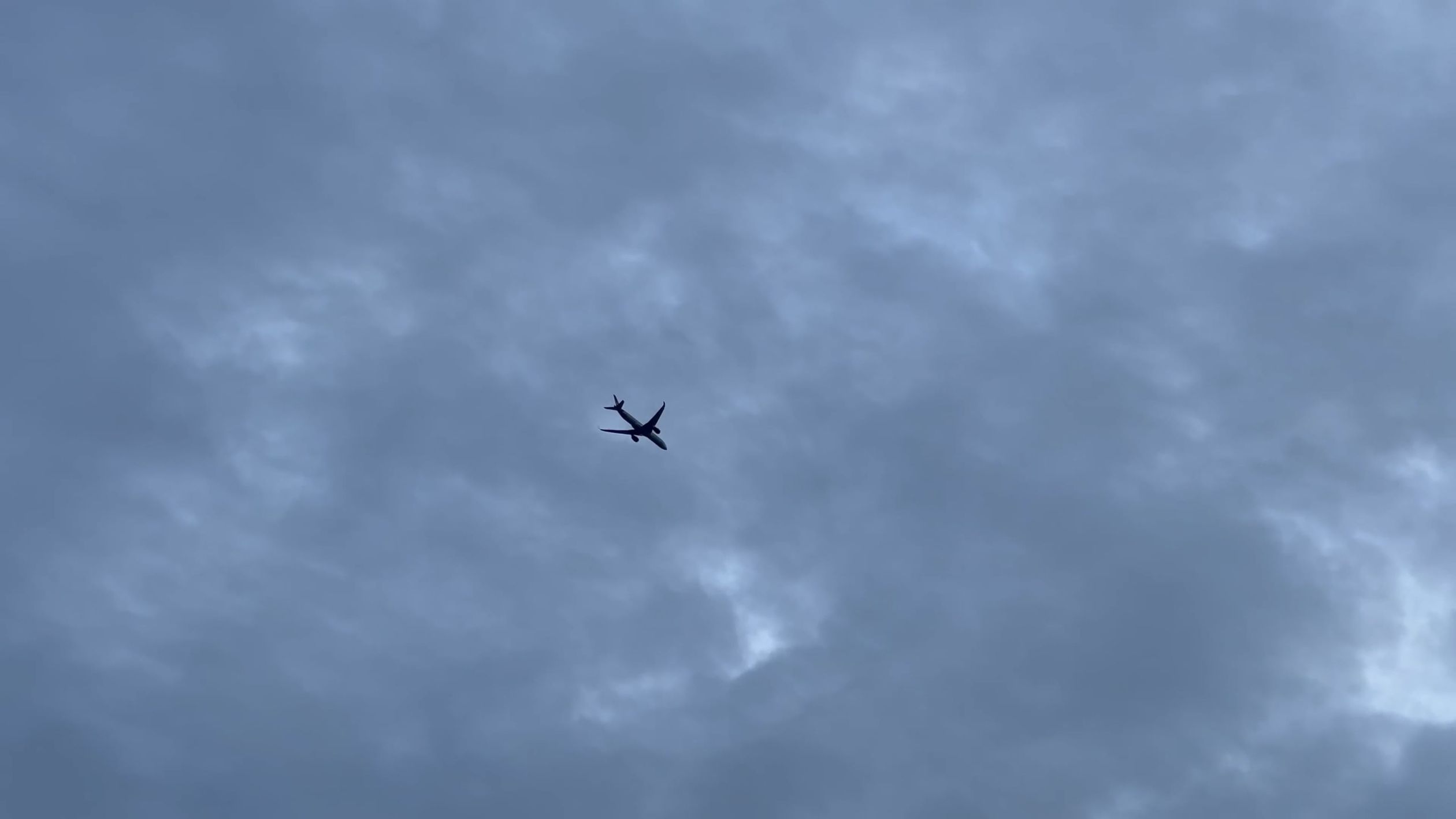 A plane flying through the cloudy sky with a blue sky Free Stock Video ...