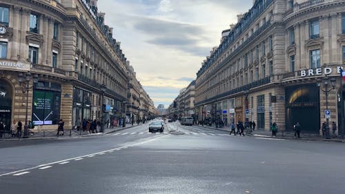 A Moving Cars on the Road Between City Buildings in Paris