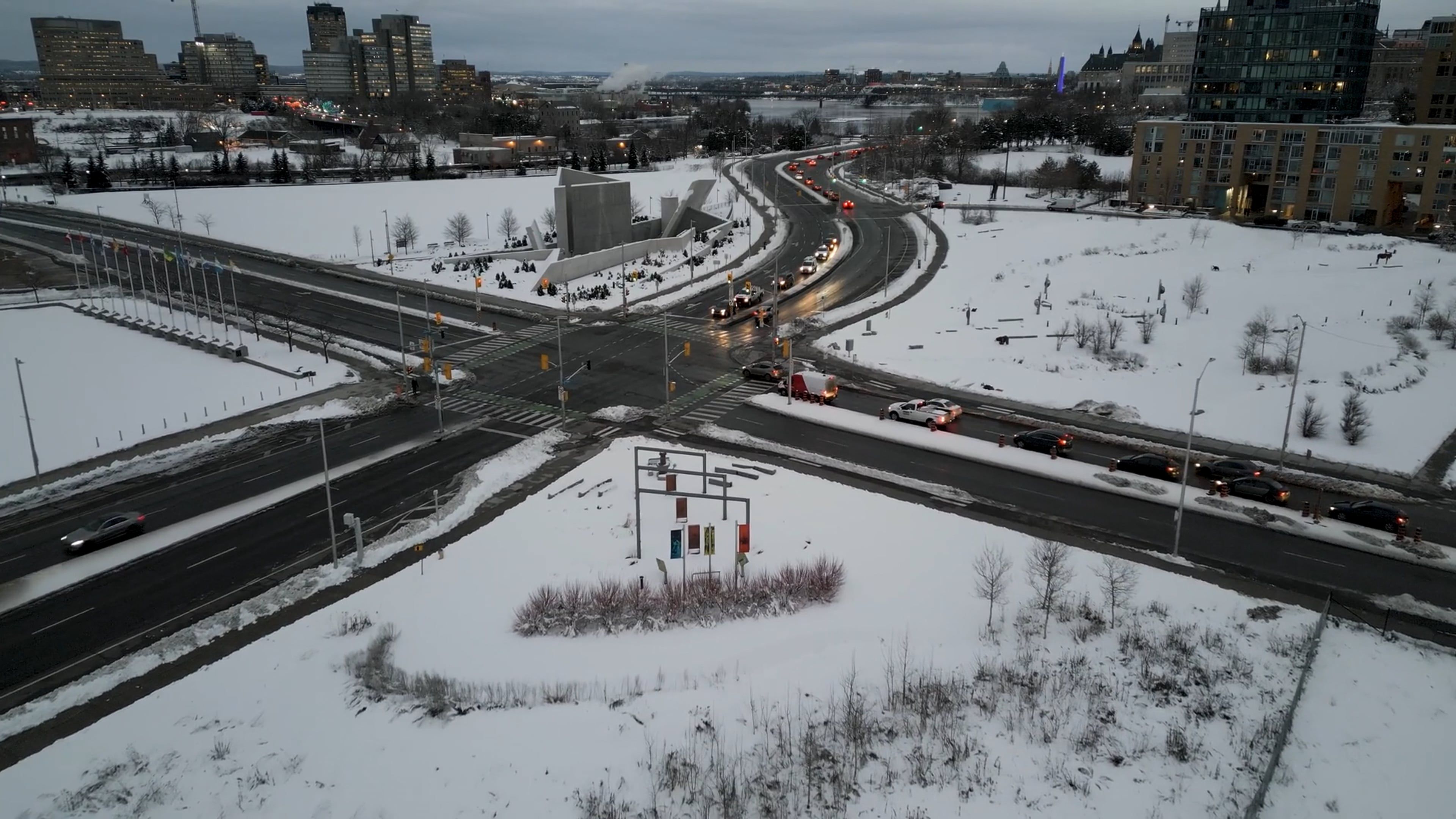 A Drone Footage of Moving Cars on the Road Between Buildings on a Snow ...