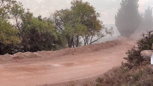 A Rally Racing Car Speeding on a Dirt Road