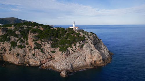 An Aerial Footage of a Lighthouse on a Rock Formation Near the Ocean