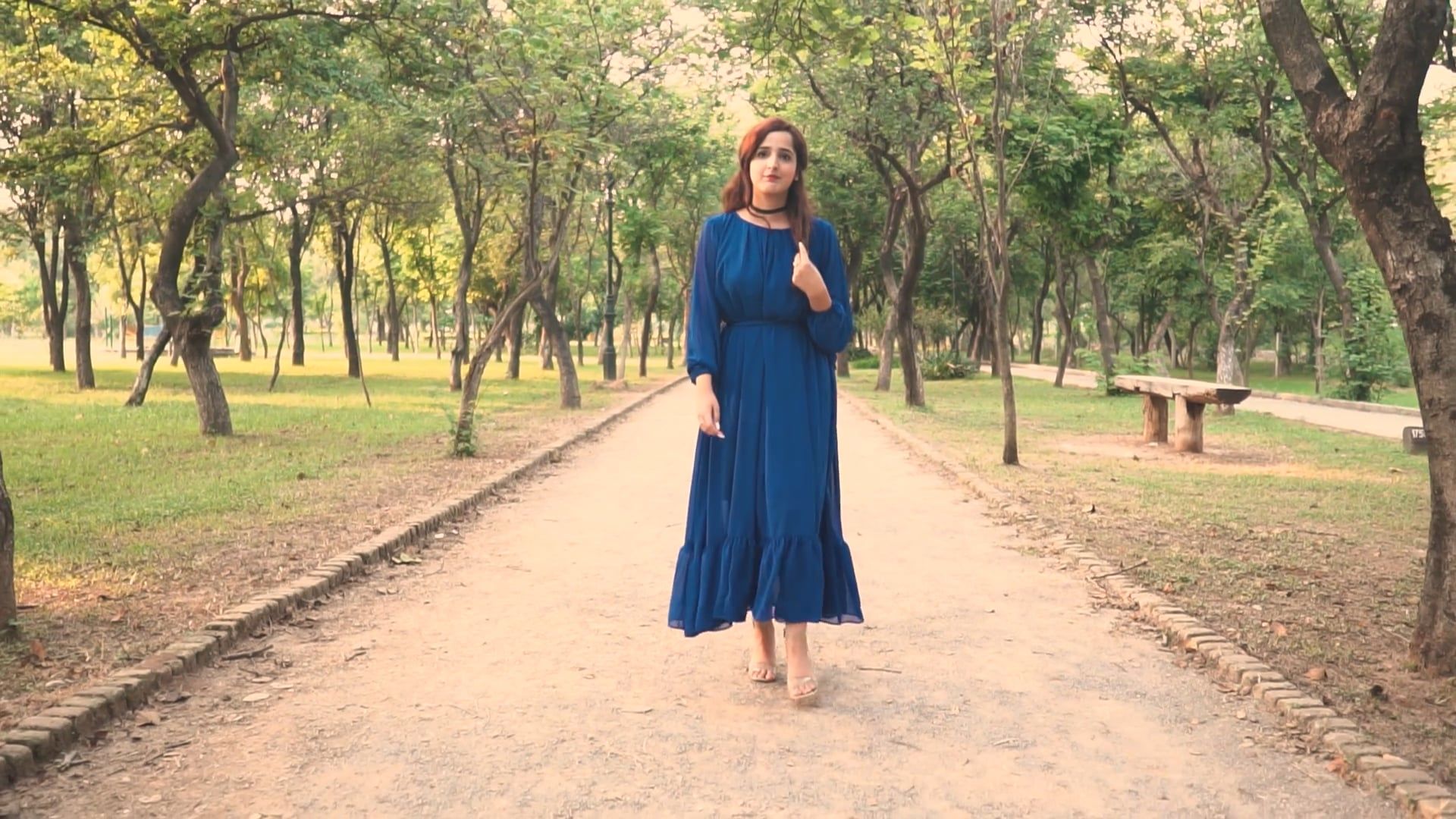 A Young Woman in a Blue Dress Walking in the Park Free Stock Video ...