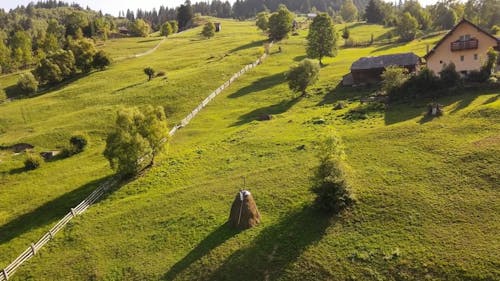 Drone Footage of Farm Houses on a Green Hill 