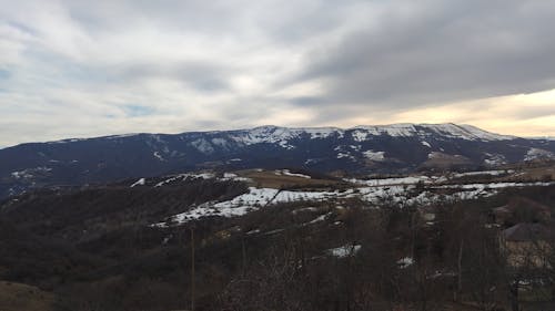 A Snow Covered Mountains Under the Cloudy Sky