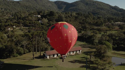 A Hot Air Balloon Landing by a Country House in a Mountain Landscape 