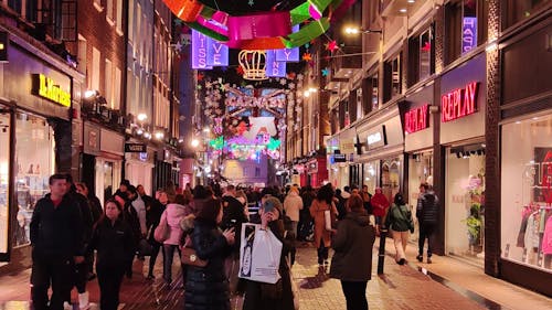 People Walking along a London Pedestrian Street Decorated with Christmas Lights