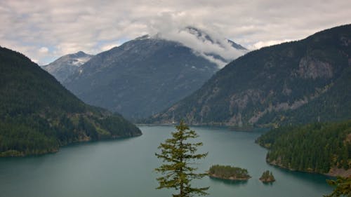 An Aerial Footage of Diablo Lake Between Green Trees on Mountains