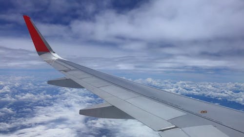 Window View of a Plane Flying above the Clouds 