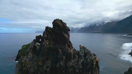 An Aerial Footage of Rock Formations and Mountains on the Sea