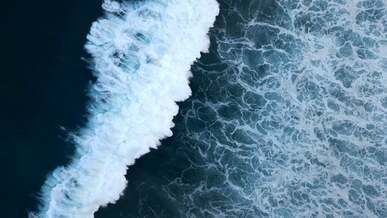an aerial footage of waves crashing on sea