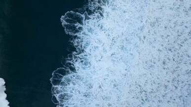 a birds eye view of waves crashing on sea