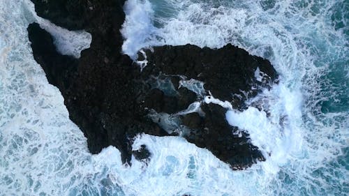 An Aerial Footage of Waves Crashing on Rock Formations
