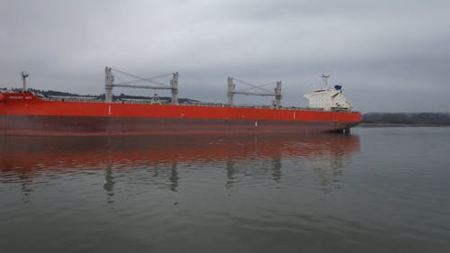 A Long Red Cargo Ship in the River 