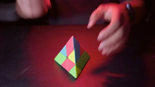 Close up of a Person Solving a Triangular Pyramid Puzzle