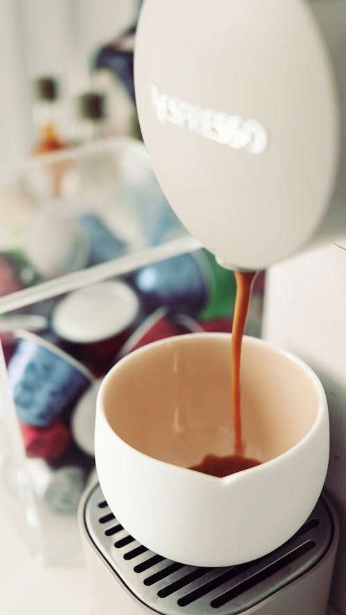 A Coffee Machine Refilling Coffee on a Cup