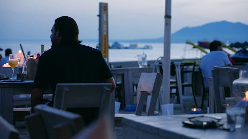Back View of a Man Dining at a Beach Cafe