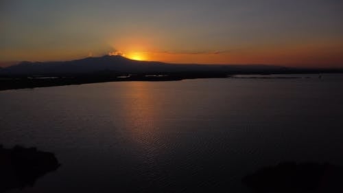 Drone Footage of a Lagoon in a Mountain Landscape at Sunset 