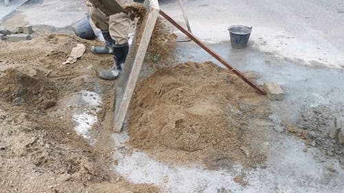 A Construction Working Sifting Sand 