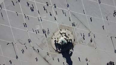 top view of people walking by a monument at a town square